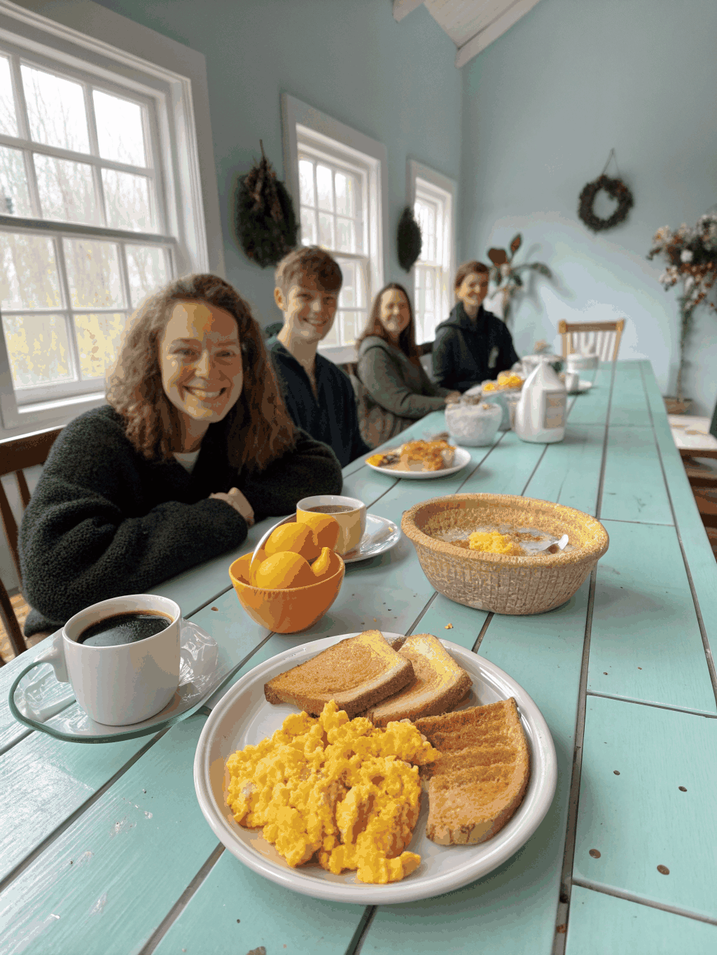 People sharing a meal at a long wooden table